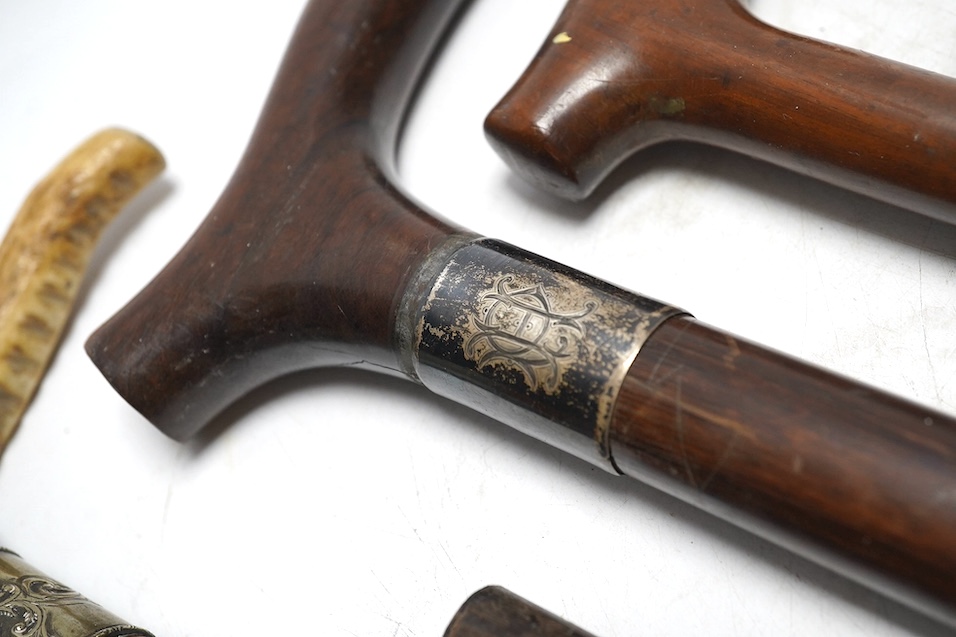 Four mixed silver mounted walking sticks, a riding crop and a baton, longest 88cm. (6). Condition - fair considering use and age